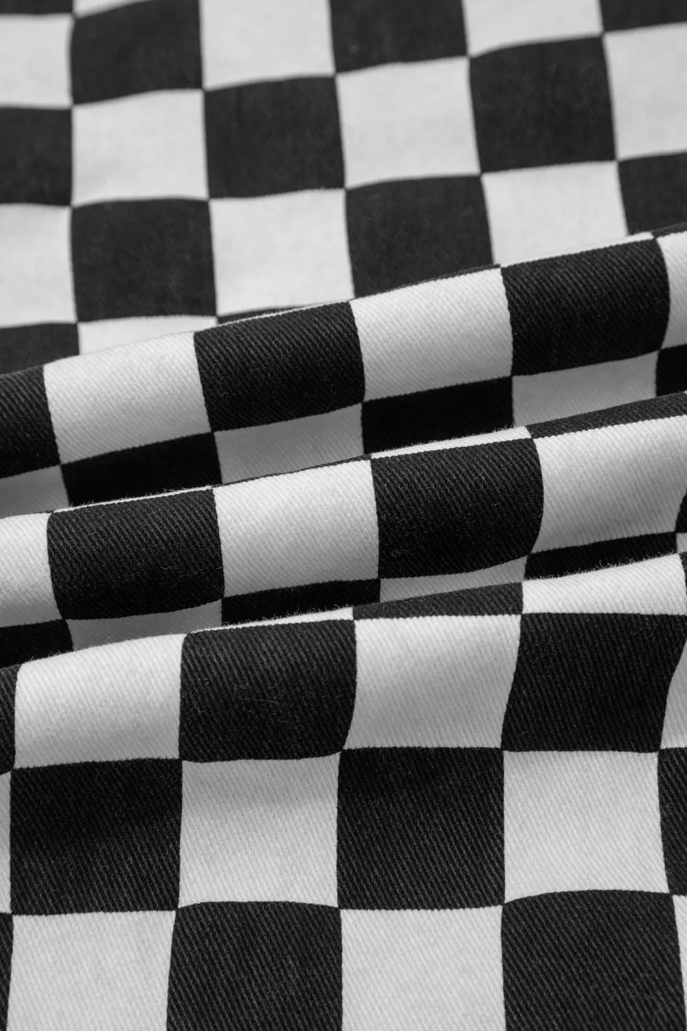 Women’s checkerboard print distressed raw edge cropped jeans by Trendsi, featuring a fashionable checkered pattern and frayed hems.