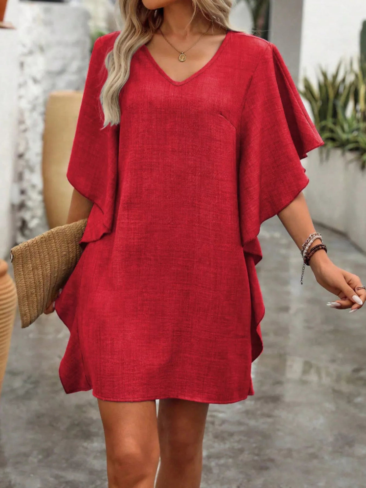 Women’s flowy V-neck casual mini dress with ruffled sleeves from Plush Fashion Hub, displayed on a hanger with a soft fabric texture.
