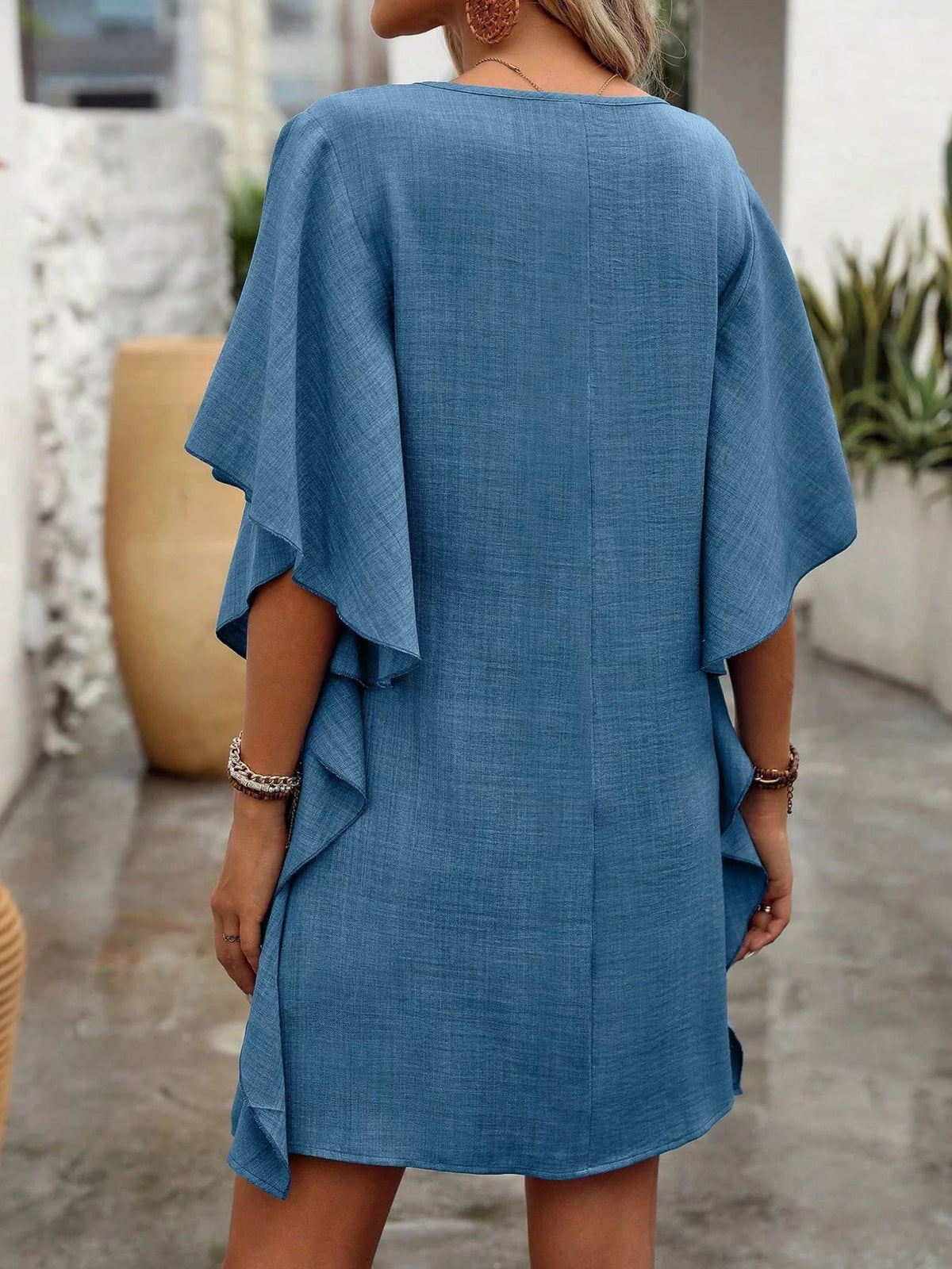 Women’s flowy V-neck casual mini dress with ruffled sleeves, from Plush Fashion Hub, shown on a model in a relaxed, stylish fit.