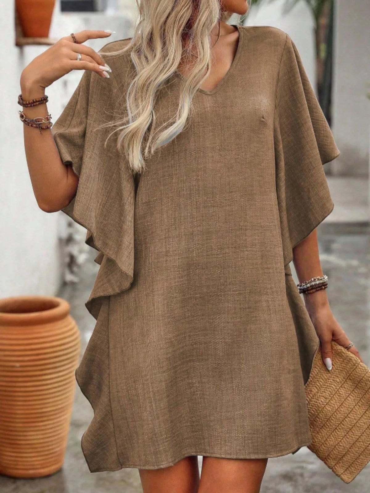 Women’s flowy V-neck casual mini dress with ruffled sleeves by Plush Fashion Hub, shown hanging on a hanger.