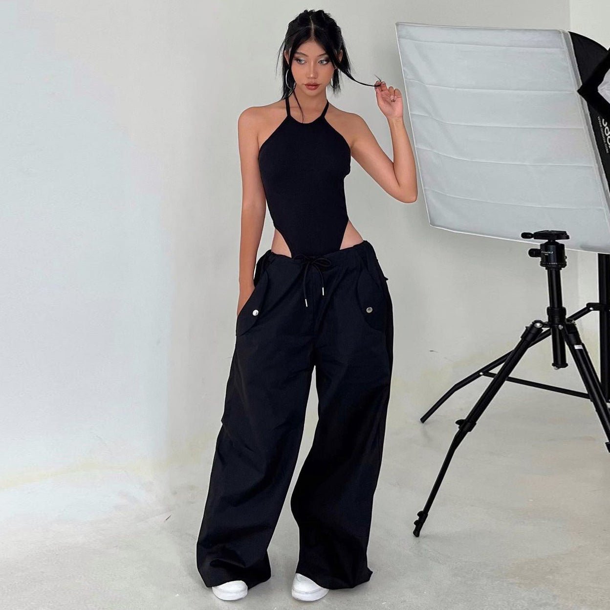 Women's high-waist lace-up straight-leg cargo pants in loose fit, casualwear by FitiqueFit, shown in a relaxed, stylish pose.
