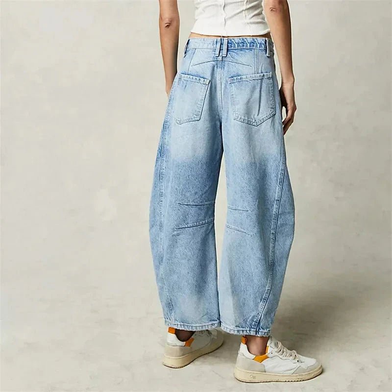Women's mid-rise wide-leg jeans by FitiqueFit, casualwear style, shown in a natural pose, highlighting the relaxed fit and denim fabric.
