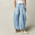 Women's mid-rise wide-leg jeans by FitiqueFit, casualwear style, shown in a natural pose, highlighting the relaxed fit and denim fabric.