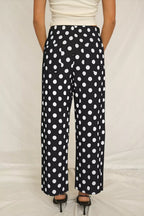 Women's polka dot straight-leg pants with pockets from Trendsi, featuring a stylish fit and classic pattern.