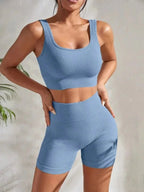 Women's seamless ribbed yoga set by FitiqueFit, featuring a fitted tank top and high-waisted leggings for activewear.