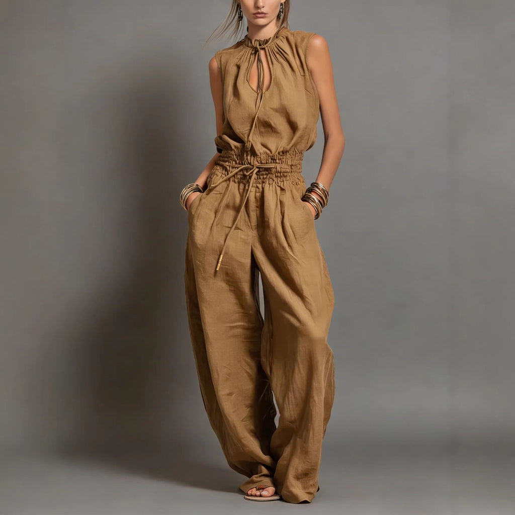Women's sleeveless high-waist wide-leg pleated jumpsuit by FitiqueFit, casualwear, shown in a neutral pose highlighting the style and fit.