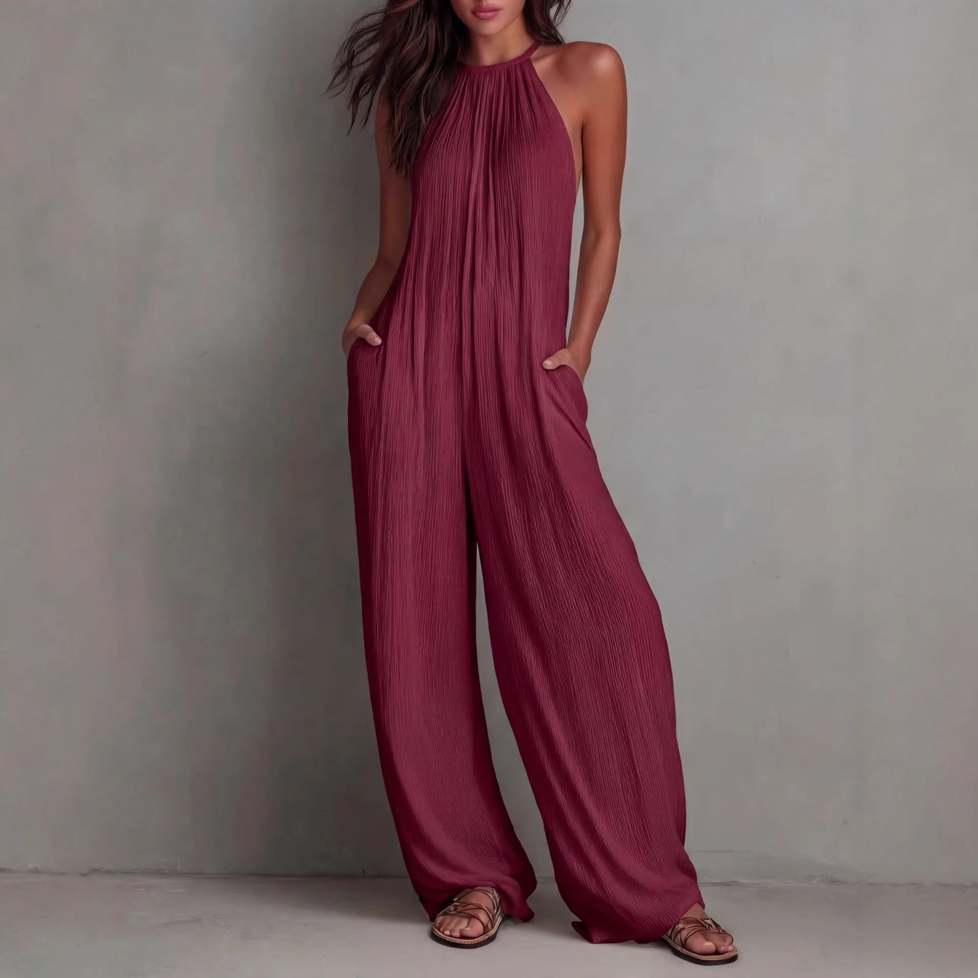Women's sleeveless open-back wide-leg pleated jumpsuit from FitiqueFit, featuring a casual style with flowing fabric and stylish design.