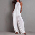 Women's sleeveless open-back wide-leg pleated jumpsuit by FitiqueFit, shown in a casual wear style with flowing fabric and stylish design.