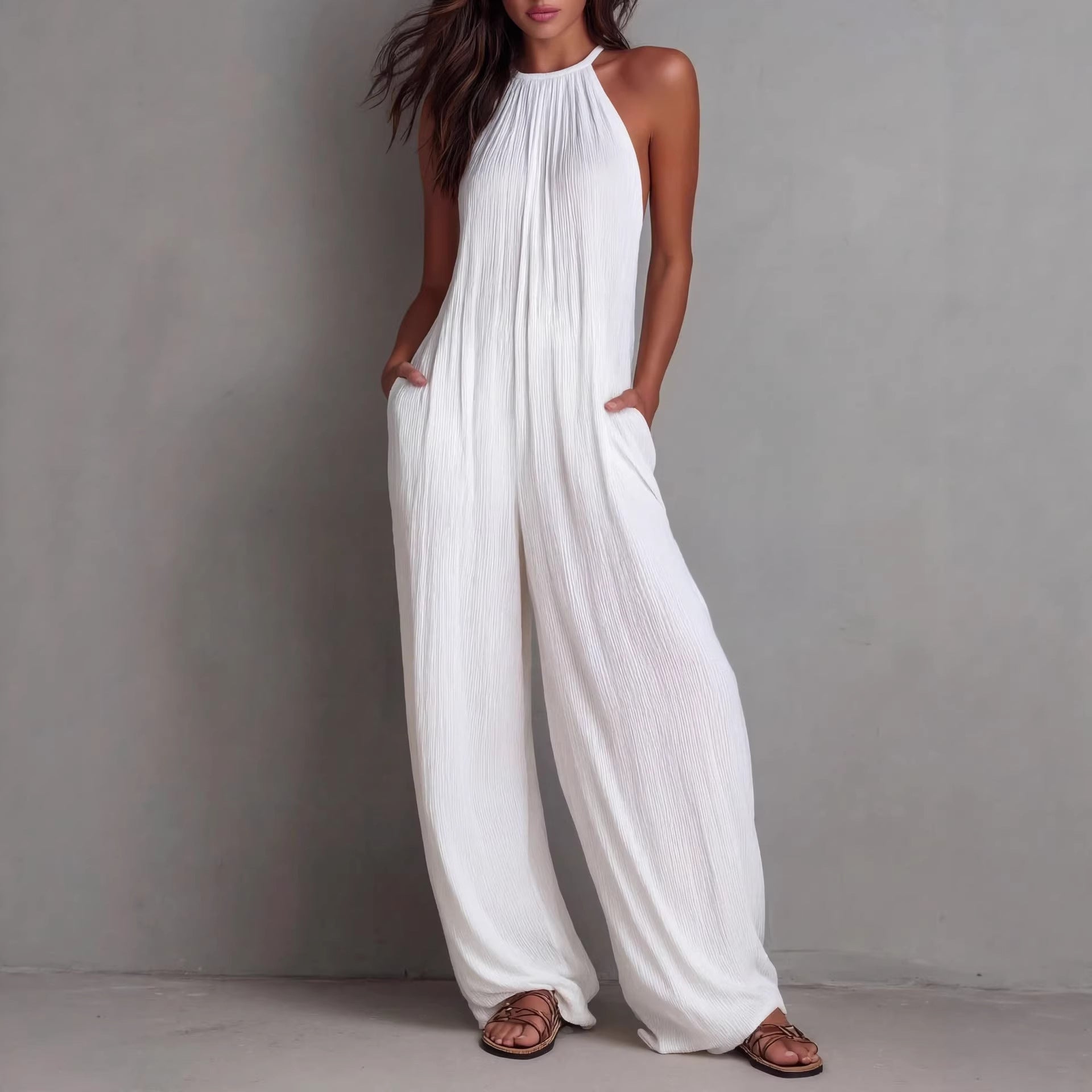 Women's sleeveless open-back wide-leg pleated jumpsuit by FitiqueFit, shown in a casual wear style with flowing fabric and stylish design.