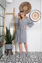 Knee-length Lotus Linen women's waffle robe hanging on a hook, showcasing soft, textured fabric and relaxed fit.